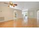 Open living room with gleaming hardwood floors, neutral paint, and an arched doorway to the kitchen at 14385 Saltby Pl, Spring Hill, FL 34609