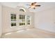 Bright main bedroom with carpet floors, ceiling fan and three windows at 14385 Saltby Pl, Spring Hill, FL 34609