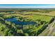 This aerial view showcases a large pond surrounded by mature trees on a sprawling rural property at 701 E 60 Hwy, Plant City, FL 33567