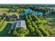 Stunning aerial view of home with pond, pool, and workshop on expansive property with mature trees and long driveway at 701 E 60 Hwy, Plant City, FL 33567