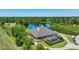 An aerial view showcasing a home with a screened-in pool, large driveway, and surrounding mature trees at 701 E 60 Hwy, Plant City, FL 33567