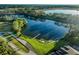 Scenic aerial view showcasing a private lake with a dock and lush landscaping surrounding the estate at 701 E 60 Hwy, Plant City, FL 33567