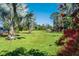 Beautiful, lush backyard with palm trees and an expansive green lawn at 701 E 60 Hwy, Plant City, FL 33567