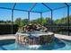 Screened in hot tub featuring stone waterfall feature and brick paver deck at 701 E 60 Hwy, Plant City, FL 33567