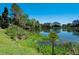 Scenic pond with a caution sign, bordered by lush greenery, reflecting the natural beauty of the property at 701 E 60 Hwy, Plant City, FL 33567