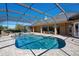 Screened-in pool area featuring an in ground pool, waterfall spa, and brick paver deck at 701 E 60 Hwy, Plant City, FL 33567