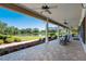 Spacious covered porch with ceiling fans offers views of the beautiful landscaped yard and waterfront at 701 E 60 Hwy, Plant City, FL 33567