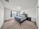 Bedroom featuring large window, carpet floors, and a dark wood bed frame at 1009 Golden Shiner Ave, Ruskin, FL 33570