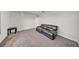 Bedroom showing a dark leather sofa, neutral carpet, and door at 1009 Golden Shiner Ave, Ruskin, FL 33570