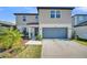 Charming two-story home with neutral siding, a two-car garage, and well-maintained landscaping at 1009 Golden Shiner Ave, Ruskin, FL 33570