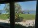 Tranquil backyard view featuring a blossoming tree and a private dock overlooking the water at 1140 Boca Ciega Isle Dr, St Pete Beach, FL 33706