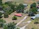 Aerial view of a red roofed home on a large lot with trees and some outbuildings at 18818 Dorman Rd, Lithia, FL 33547