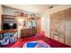 Bedroom with red carpet, wood closet doors, and shelves displaying dolls and a TV at 18818 Dorman Rd, Lithia, FL 33547
