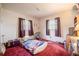 Bedroom with red carpet, two windows with curtains, and basic furnishings at 18818 Dorman Rd, Lithia, FL 33547