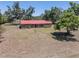 Charming ranch-style home featuring a red metal roof and lush landscaping on a spacious lot at 18818 Dorman Rd, Lithia, FL 33547