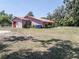 Rear exterior view showing house with red metal roof and large backyard at 18818 Dorman Rd, Lithia, FL 33547