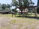 Covered outbuilding with metal roof, supported by posts, and trees in the background at 18818 Dorman Rd, Lithia, FL 33547