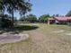 View of the property surrounded by established trees and a grassy field at 18818 Dorman Rd, Lithia, FL 33547