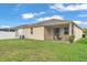 Exterior view of the backyard featuring the screened-in lanai and lush green lawn at 3134 Macintosh Rd, Land O Lakes, FL 34639