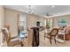 Open concept dining area with modern chandelier, glass table, and comfortable seating at 3134 Macintosh Rd, Land O Lakes, FL 34639