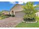 Well-maintained front yard featuring brick-paved driveway and manicured landscaping at 3134 Macintosh Rd, Land O Lakes, FL 34639