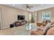 Comfortable living room with ceiling fan, neutral walls, plush rug, and sliding glass door to the exterior at 3134 Macintosh Rd, Land O Lakes, FL 34639