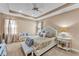 Bright main bedroom featuring a tray ceiling, ceiling fan, and a seating area at 3134 Macintosh Rd, Land O Lakes, FL 34639