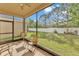 Covered and screened patio with ceiling fan and seating area overlooking the lawn at 3134 Macintosh Rd, Land O Lakes, FL 34639