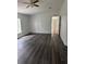 Bedroom featuring a ceiling fan and a view into the hallway with new dark wood-style floors at 39204 Bay Ave, Zephyrhills, FL 33540