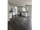 Kitchen with white appliances and cabinets featuring new dark, wide-plank wood-style floors at 39204 Bay Ave, Zephyrhills, FL 33540