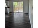 Living room area leading to outdoor deck area with dark, wide-plank floors at 39204 Bay Ave, Zephyrhills, FL 33540
