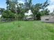 Large fenced backyard with mature trees, providing ample room for outdoor activities at 115 W Lee St, Plant City, FL 33563