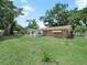 Expansive backyard featuring a lush lawn and mature trees providing ample shade at 115 W Lee St, Plant City, FL 33563