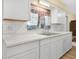 White cabinets and tile backsplash in updated kitchen with stainless sink at 115 W Lee St, Plant City, FL 33563