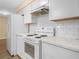 Well-lit kitchen with stainless steel appliances, white cabinets, and ample counter space at 115 W Lee St, Plant City, FL 33563