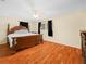 Main bedroom featuring a carved wood bed frame and wood flooring at 115 W Lee St, Plant City, FL 33563