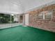Enclosed sunroom featuring brick walls, screens, and green flooring at 115 W Lee St, Plant City, FL 33563
