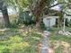 Charming single-story home featuring a mature tree-lined front yard and a covered front porch entry at 2415 Goldenrod St, Sarasota, FL 34239