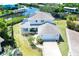 Aerial view of a two-story home with a two car garage, lush yard and canal in the background at 4116 4Th Ne Ave, Bradenton, FL 34208