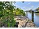 Wooden dock and waterfront views, partially obscured by foliage at 4116 4Th Ne Ave, Bradenton, FL 34208