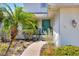 Inviting front entrance features a charming, light-teal door surrounded by lush landscaping at 4116 4Th Ne Ave, Bradenton, FL 34208