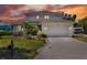 Two-story home featuring a lush landscaped yard, two car garage, and a beautiful sunset at 4116 4Th Ne Ave, Bradenton, FL 34208