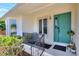 Cozy front porch features a light teal door with black iron details and a sitting area at 4116 4Th Ne Ave, Bradenton, FL 34208
