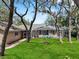 A green backyard leads to a covered pool and patio area with a fire pit at 6007 Hammock Hill Ave, Lithia, FL 33547