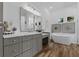 Bright bathroom featuring double mirrors, granite vanity and free standing tub at 6007 Hammock Hill Ave, Lithia, FL 33547