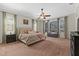 Spacious bedroom featuring a ceiling fan, plush carpeting, and views of the screened lanai at 6007 Hammock Hill Ave, Lithia, FL 33547