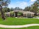 Stunning single-story home with lush landscaping and beautiful curb appeal on a bright sunny day at 6007 Hammock Hill Ave, Lithia, FL 33547