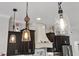 Pendant lights highlight the kitchen with a modern range hood and cabinetry at 6007 Hammock Hill Ave, Lithia, FL 33547