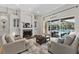 Elegant living room showcasing a fireplace, built-in cabinets, and sliding glass doors leading to an outdoor pool area at 6007 Hammock Hill Ave, Lithia, FL 33547