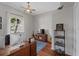 Bright home office featuring a large window, ceiling fan, wood floors, and built-in desk with an Apple monitor at 6007 Hammock Hill Ave, Lithia, FL 33547